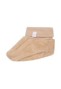 Chausson beige en tissu doux avec une bordure côtelée. Fabriqué en tissu texturé, en forme de bout ouvert pour plus de confort et de liberté de mouvement. Détails de l'étiquette blanche.