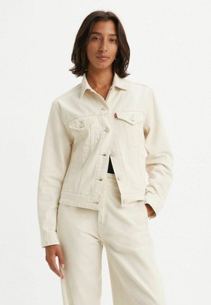 Chaqueta de mezclilla blanca con un diseño ajustado, cuello puntiagudo y cierre de botones. Presenta dos bolsillos en el pecho y detalles de costura sutiles.