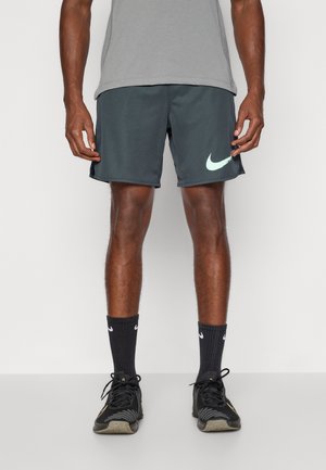 Vīriešu tumši pelēki sporta šorti ar gaiši mentolzaļu Nike logotipu. Izmantojot melnas zeķes un melnus sporta apavus, kuriem ir struktūrēts dizains un elpojošs audums.
