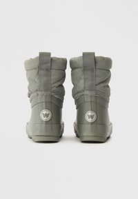 Bottes imperméables grises avec un design matelassé, deux anses à l'arrière pour un enfilage facile, texture lisse et accents de logo circulaire sur les talons.