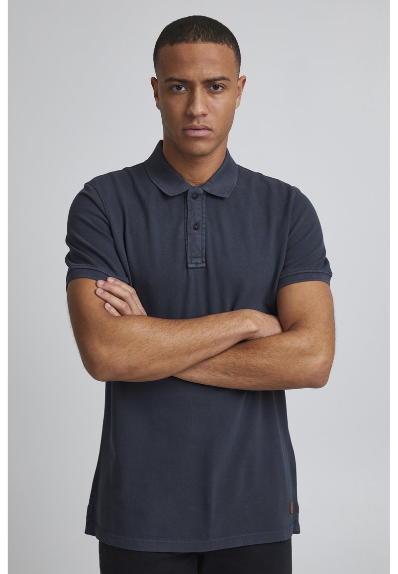 Námořnická polos tričko s krátkými rukávy, knoflíkovou légou a strukturovanou látkou. Obsahuje malou logo aplikaci blízko lemu. Standardní střih.