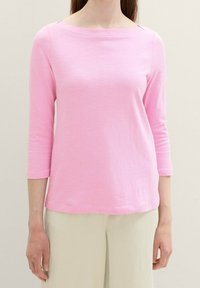 Pink long-sleeve top with a boat neckline, made from lightweight fabric, featuring a relaxed fit and subtle texture.