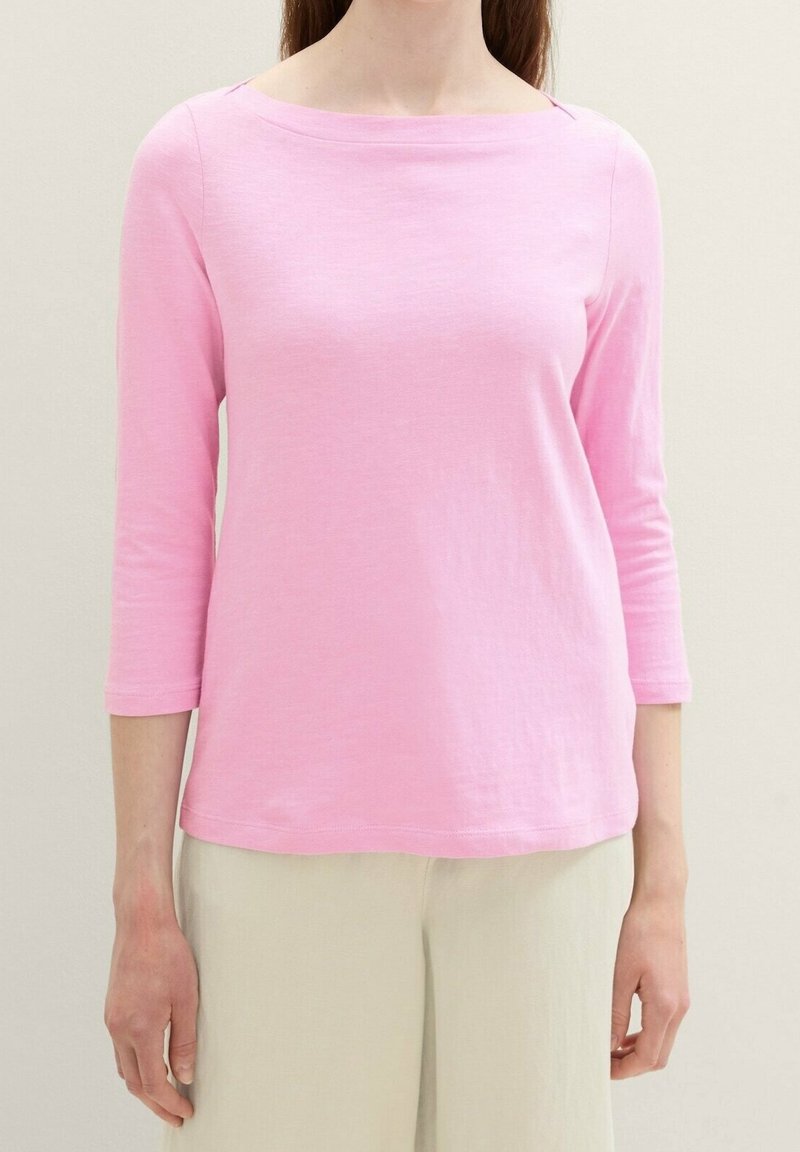 Pink long-sleeve top with a boat neckline, made from lightweight fabric, featuring a relaxed fit and subtle texture.