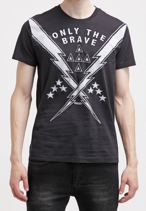 Schwarzes T-Shirt mit gekreuzten weißen Blitzsymbolen, sieben Sternen, sechs Dreiecken und dem Schriftzug "ONLY THE BRAVE" auf der Brust.