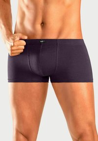 Dunkelviolette Herren-Boxershorts mit glatter Textur, elastischem Bund mit Markenetikett und enganliegendem Design, das die Silhouette betont.