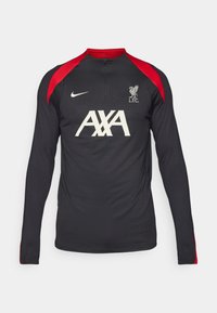 Langärmliges schwarzes Trainingstop mit roten Akzenten und Reißverschlusskragen. Mit dem Liverpool FC-Logo und AXA-Branding in Weiß auf der Vorderseite.