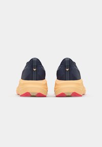 Baskets de course navy avec semelle orange et accents roses. Présentent un dessus texturé et un design ergonomique et élancé. Talon renforcé pour un soutien.