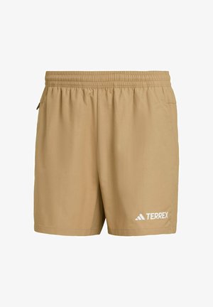 Beige Shorts aus leichtem Material mit einem elastischen Bund, seitlichen Taschen und einem weißen "TERREX"-Logo unten links.