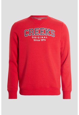 Felpa rossa in cotone con scollatura a girocollo, caratterizzata dal testo "CREEKS ORIGINAL Dal 1974" in bianco e blu navy, e polsini e orlo a costine.