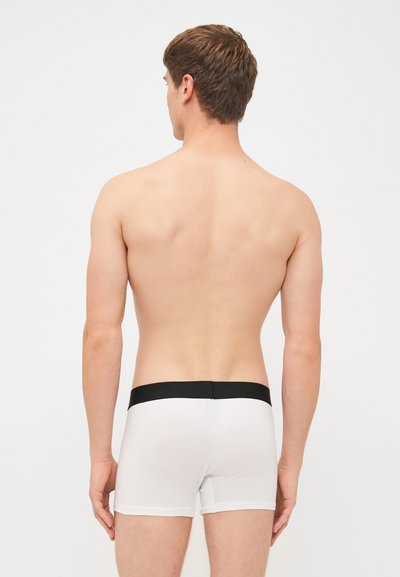 White boxer briefs with a black elastic waistband, showing a smooth texture and a fitted design from the back on a neutral background.