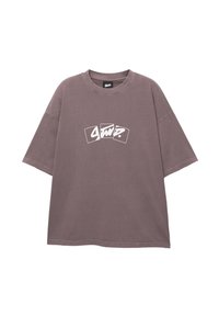 Overdimensioneret kortærmet t-shirt i blød mauve bomuld. Har et hvidt grafisk textdesign på forsiden og en rund halsudskæring.