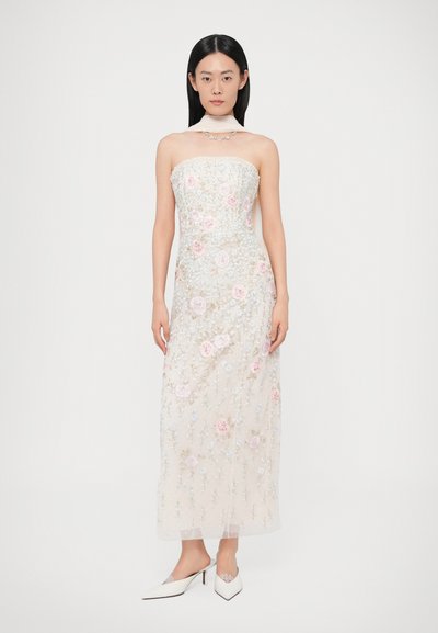 Wieczorowa sukienka bez ramiączek z cielistego tiulu, ozdobiona różowymi i niebieskimi aplikacjami kwiatowymi. Posiada dopasowany gorset i zwiewną sylwetkę, zestawiona z białymi szpilkami.