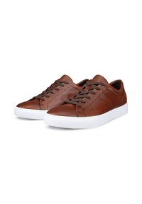 Paire de baskets basses en cuir marron avec des lacets marron foncé et des semelles en caoutchouc blanches sur fond blanc.