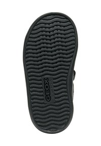Semelle de chaussure noire en caoutchouc présentant un motif de traction ondulé, une surface texturée et un logo Geox au centre, conçue pour l'adhérence et la ventilation.