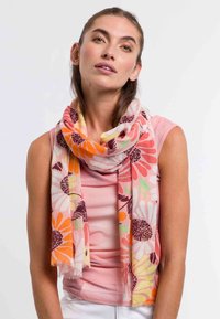 Fular floral ușor, cu margarete mari portocalii și roz, accentuate cu verde, pe un fundal deschis. Marginile desfăcute adaugă textură.