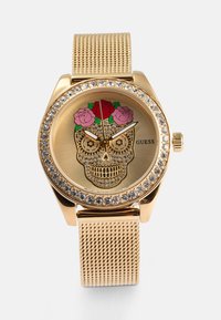Gold metal watch with a skull design, adorned with colorful roses and surrounded by rhinestones on the bezel. Mesh strap finishes the look.