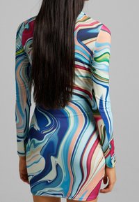 Mini-Kleid mit langen Ärmeln in mehrfarbigen, wirbelnden Mustern in Blau, Pink, Grün und Creme; gefertigt aus einem glatten, dehnbaren Stoff.