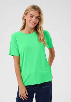 Neongrön kortärmad t-shirt med rund halsringning, tillverkad av ett slätt tyg; kombinerat med mörk indigo jeans. Inga synliga mönster eller detaljer.