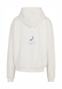 Sudadera blanca con capucha que presenta un gráfico de pluma lavanda en la parte trasera, con texto abajo en morado. Tejido suave, corte relajado, puños acanalados.