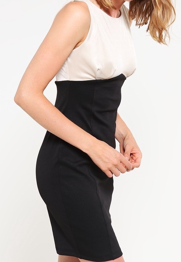 Robe sans manches noire et beige avec une silhouette ajustée, présentant un haut beige lisse et une jupe noire texturée.