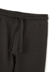 Pantalones de chándal gris oscuro con una cinturilla elástica, cordones ajustables y una textura suave, que presentan un diseño sencillo sin patrones.
