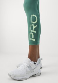 Nike Performance Leggingek - bicoastal/vapor green/white