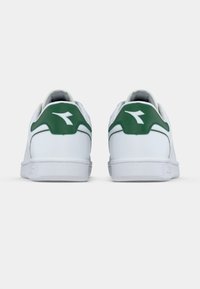 Λευκά αθλητικά παπούτσια με υφασμένο ελαστικό πέλμα, πράσινη λεπτομέρεια στη φτέρνα και λείο συνθετικό επάνω μέρος. Διαθέτουν διακριτικό λογότυπο στο πίσω μέρος.