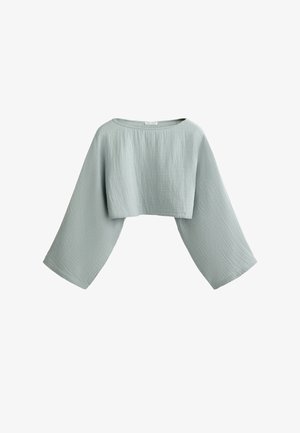 Ljusgrön kort topp i textilier med struktur. Har vida, klockärm och båthals. Inga synliga knäppningar eller dekorationer.