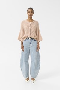 Gebreid roze cardigan met grote knopen, wijde mouwen; gecombineerd met losse lichtblauwe spijkerbroek en crèmekleurige puntige schoenen.