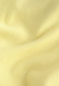 Tissu côtelé jaune doux avec de fines lignes verticales et de légers plis créant une surface texturée légèrement ondulée.