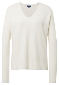 Kremowy sweter z długim rękawem i dekoltem w serek, wykonany z teksturowanej tkaniny, o prostym kroju i z małą naszywką z logo na dole.