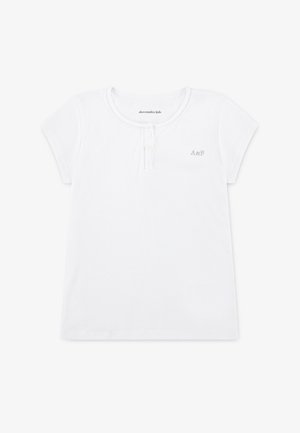 Biała koszulka z krótkim rękawem, z zaokrąglonym dekoltem, o fakturze prążkowanej i trzema guzikami przy kołnierzu. Na piersi ma małe haftowane logo "A&F".