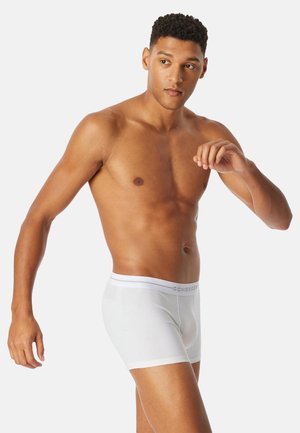 Boxer elasticizzati in cotone bianco con fascia elastica in vita. Il nome del marchio è discretamente stampato sulla fascia in grigio.