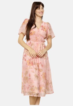 Bloemen midi-jurk in zachtroze met korte pofmouwen en een rimpel taille. Heeft een lichte, vloeiende stof met pastel bloemenpatronen.
