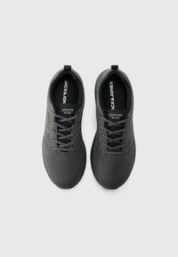 Black athletic shoes with a textured mesh upper, round toe, and lace-up design. Features branding on the tongue and side.