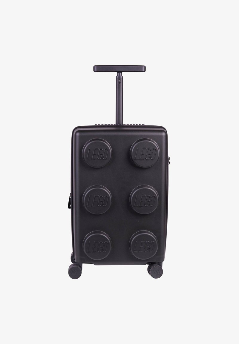Svart hårdskalresväska med sex upphöjda LEGO-bitar-designs, ett teleskophandtag och fyra hjul för rörlighet.