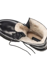 Svart läder ankelboot med en mjuk, krämfärgad foder och snörningsdesign. Har en rundad tå och en texturerad sula.