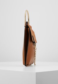 Ruskea nahkalaukku, jossa on kultainen metallikahva ja ketjuvalmistelu. Kapea muotoilu, jossa on l�äppäklipsi ja kontrastiset mustat reunat.