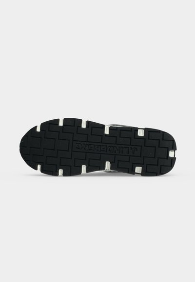 Semelle de chaussure en caoutchouc noir avec un motif de bande de roulement profond et le nom de la marque "J.LINDEBERG" embossé au centre.