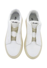 Białe skórzane sneakersy z elastycznym beżowym paskiem, zaokrąglonym noskiem i gumową podeszwą. Wnętrze z miękką podszewką ozdobioną logo.