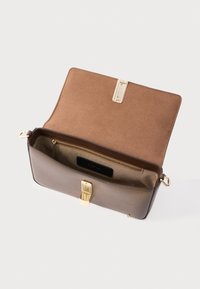 Brūna ādas rokas soma ar gludu virsmu, zelta detaļām, mīkstu brūnu oderi un iekšējo nodalījumu ar rāvējslēdzēju. Aizvēršana ir ar zelta aizdari.