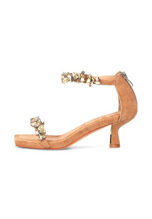 Sandalias de tacón alto de ante color nude con punta cuadrada, correa en el tobillo adornada y gemas decorativas. Diseño de pequeño tacón cuadrado con cremallera.