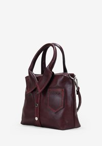 Bolso de cuero burdeos con asas dobles, botones a presión delanteros, un bolsillo parche y una correa de hombro desmontable con herrajes plateados.