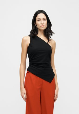 Schwarzes, einseitig schulterfreies Top mit drapiertem Design, figurbetonter Form und weicher Textur, kombiniert mit orangenen Hosen mit weitem Bein.