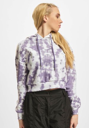 Skraćena trenerka v belem in vijoličnem tie-dye vzorcu, ki ima kapuco z vrvico, rebraste manšete in vdelano besedilo na prsih.