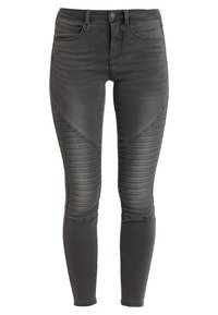 Jeans skinny de mezclilla negra con acentos acolchados a lo largo de los muslos exteriores y un clásico diseño de cinco bolsillos. Silueta ajustada en toda la prenda.
