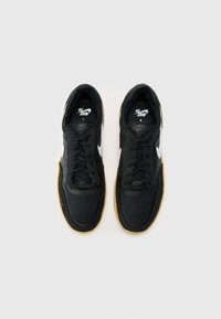 Tenis de malha pretos com um logo Swoosh branco, apresentando uma superfície texturizada e uma sola de borracha de goma. Projetados com atacadores para um ajuste seguro.