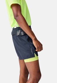 Herrarnas träningsshorts i svart med gula detaljer. Lätt och andningsbart material med ett mesh-foder, med en säker midjeband och sidofickor.