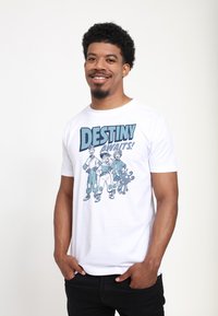 Camiseta blanca de algodón con un diseño gráfico de tres personajes de dibujos animados y texto que dice "¡EL DESTINO TE ESPERA!" en azul.