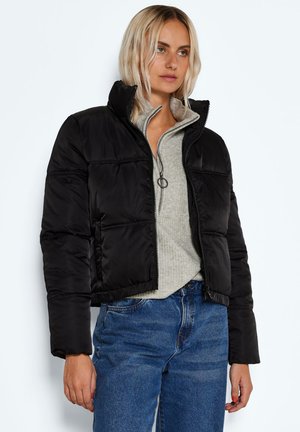 Svart boblejakke med en kort design, glidelås i front, høy krage og horisontale sømmer, lagd over en lys grå sweatshirt.